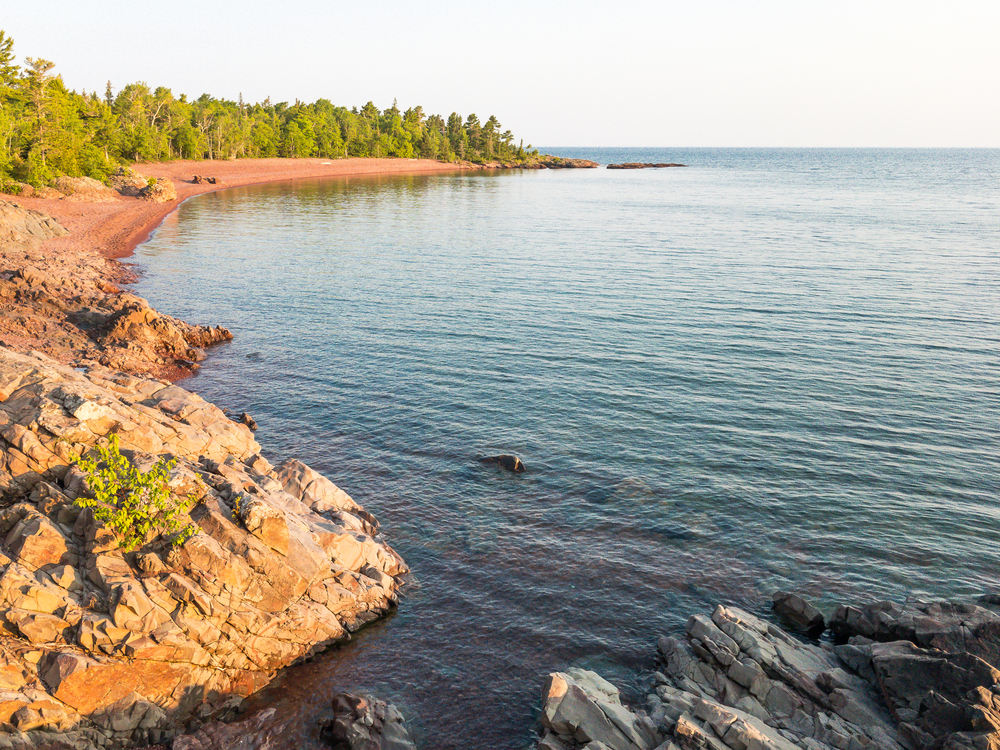 Rocky shoreline of Hunter's Point in Michigan. Blue waters reaching the shoreline.