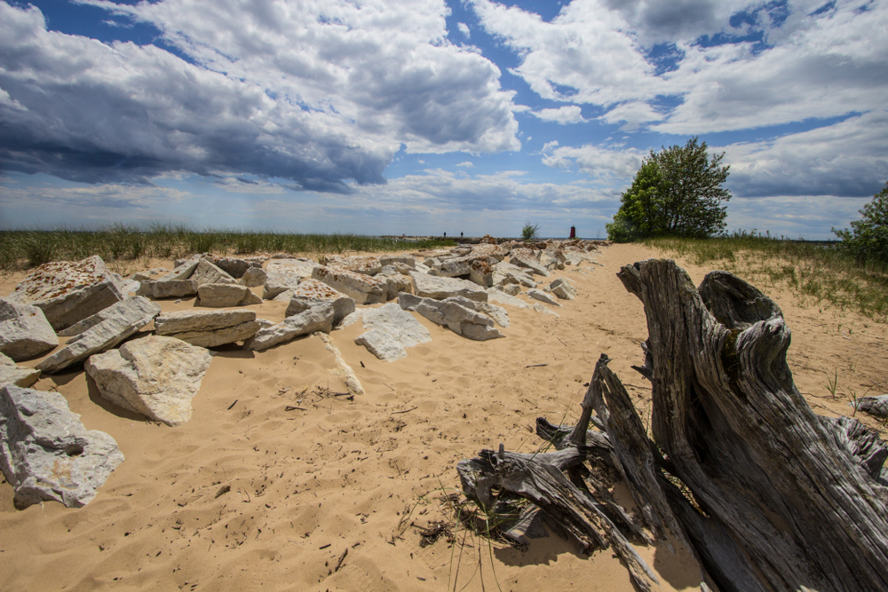 Manistique sandy beach in UP Michigan with rocks and driftwood.