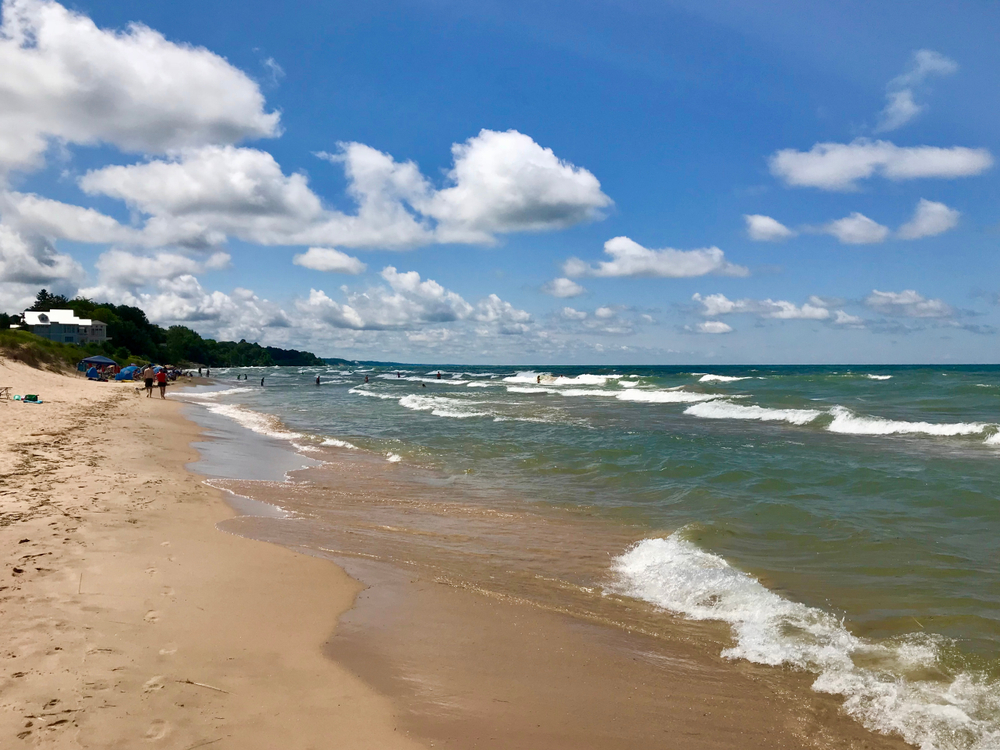 Sandy South Haven Beach in Michigan with large rolling waves washing up on it.