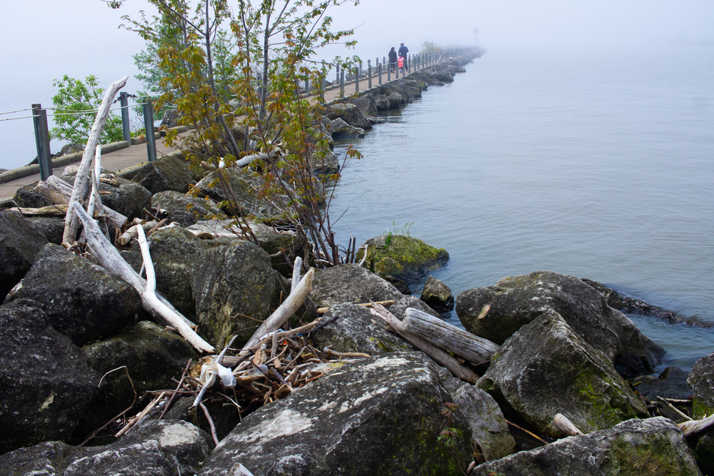 Boardwalk at Lakeview Park with rock outcroppings and calm waters of Lake Erie.