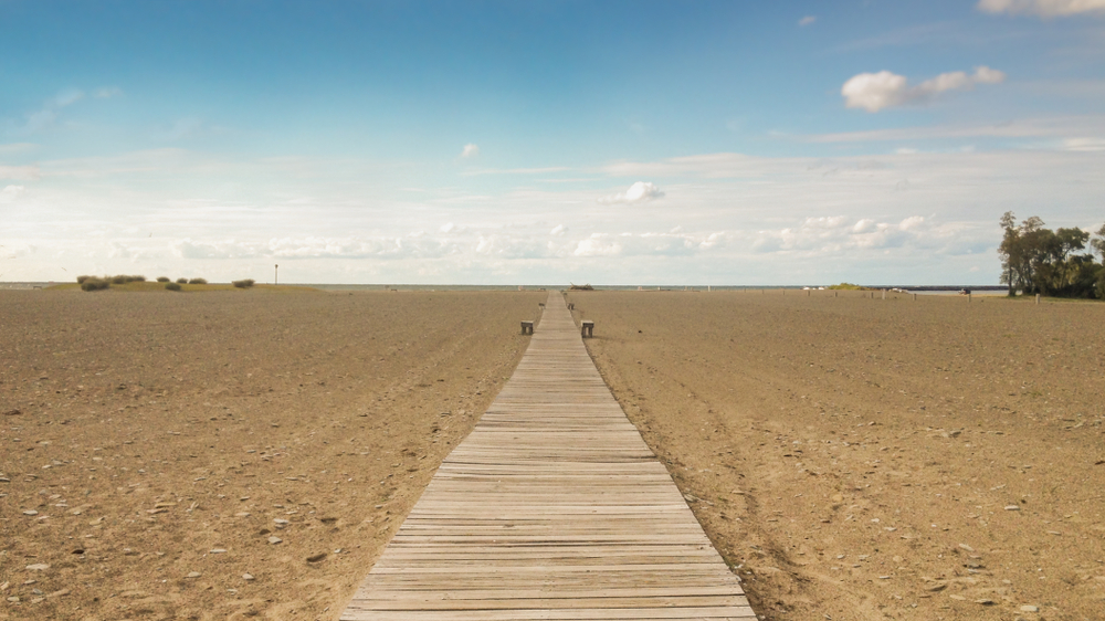 Large boardwalk through sandy beach leading to Lake Erie.
