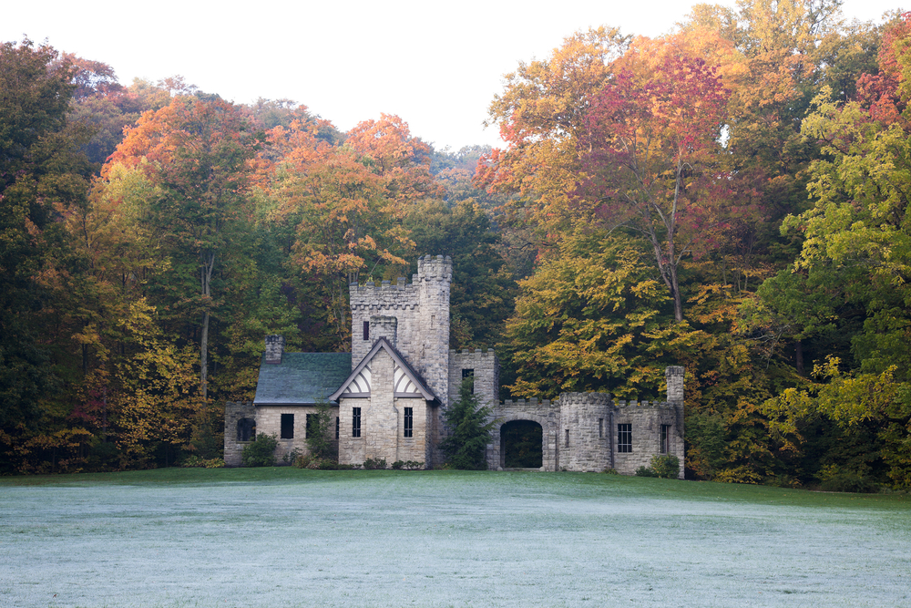Beautiful stone castle in Ohio surrounded by trees with large front lawn.