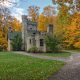 Photo of romantic European-inspired gothic castle in Ohio surrounded by autumnal trees with a large green front yard.