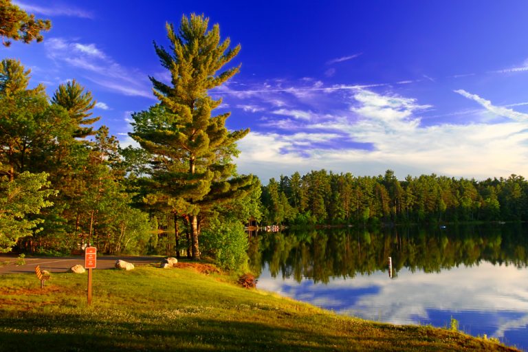 Green trees surrounding clear blue lake Northwoods, Wisconsin. 