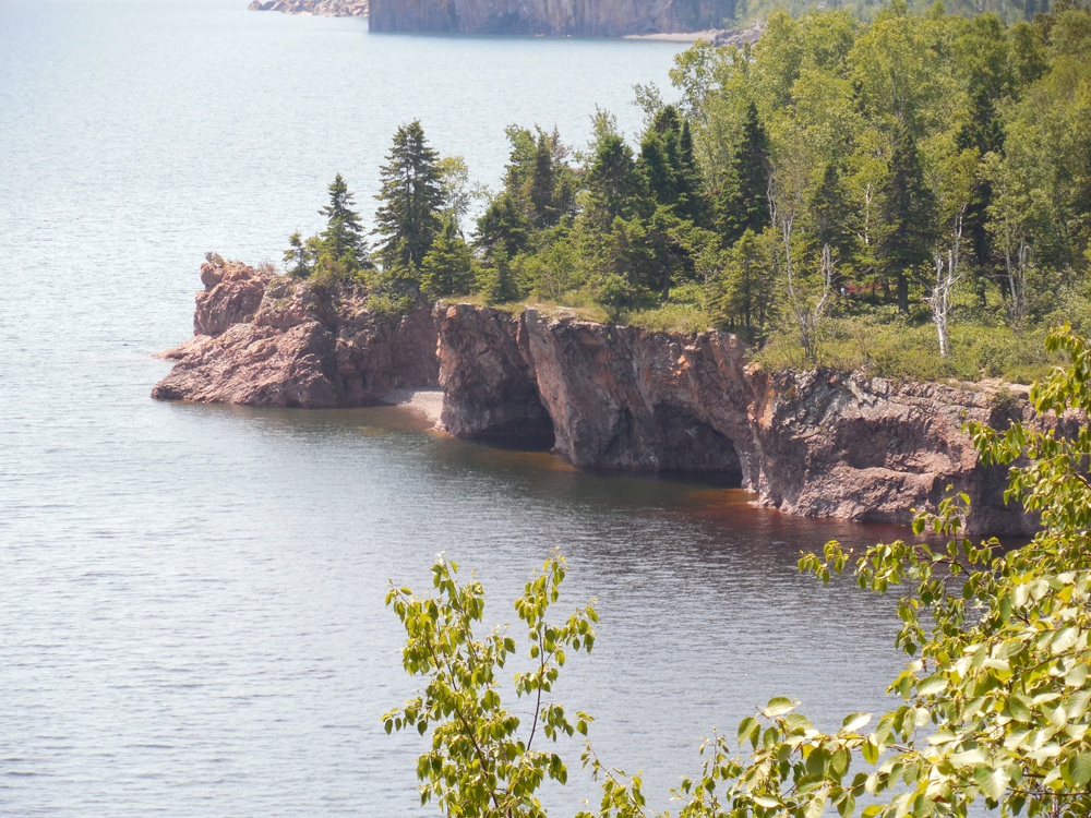 Spectacular scenery small town Minnesota with jagged cliffs topped with evergreen trees on shores of Lake Superior.