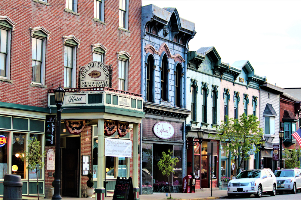 Charming downtown Millersburg with architecturally interesting buildings and cars parked in street.