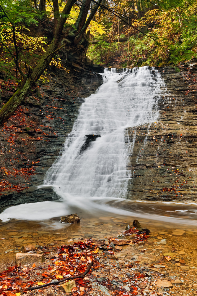 Cascading down rocks with forest in background Buttermilk Falls, one of the best waterfalls in Ohio.