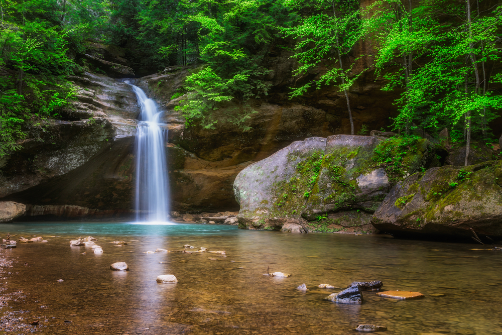 A waterfall surrounded by greenery in Hocking Hills State Park in Ohio