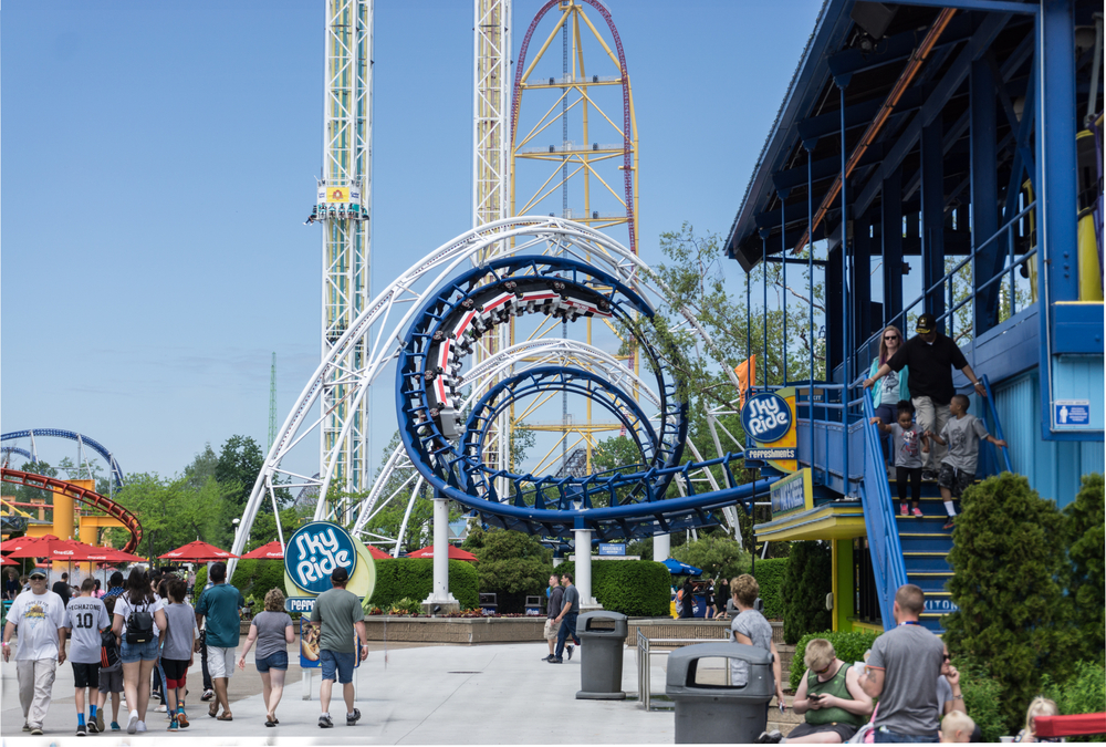 Cedar Point blue roller coaster in foreground with thrill rides in background.