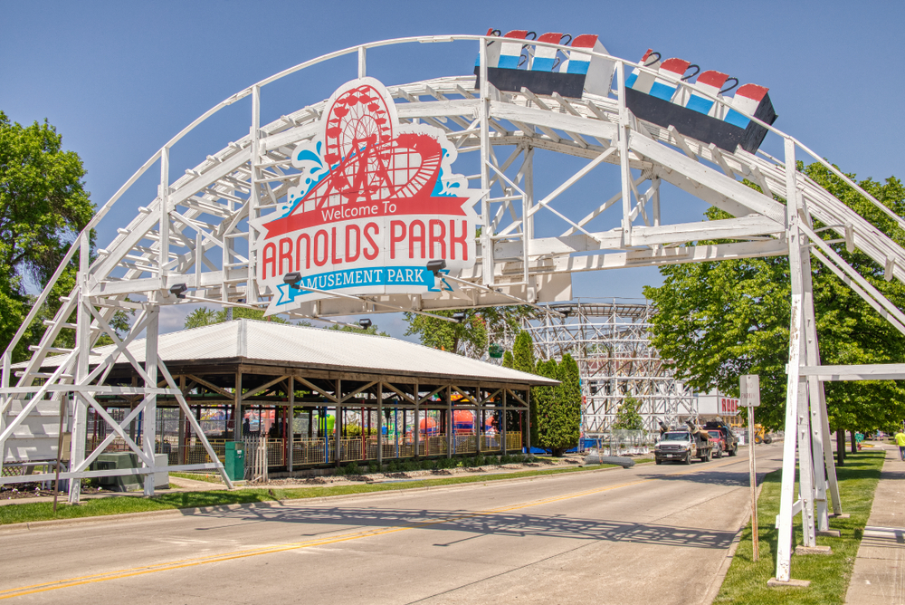 A white metal arch entrance to Arnolds park an amusement park in the midwest