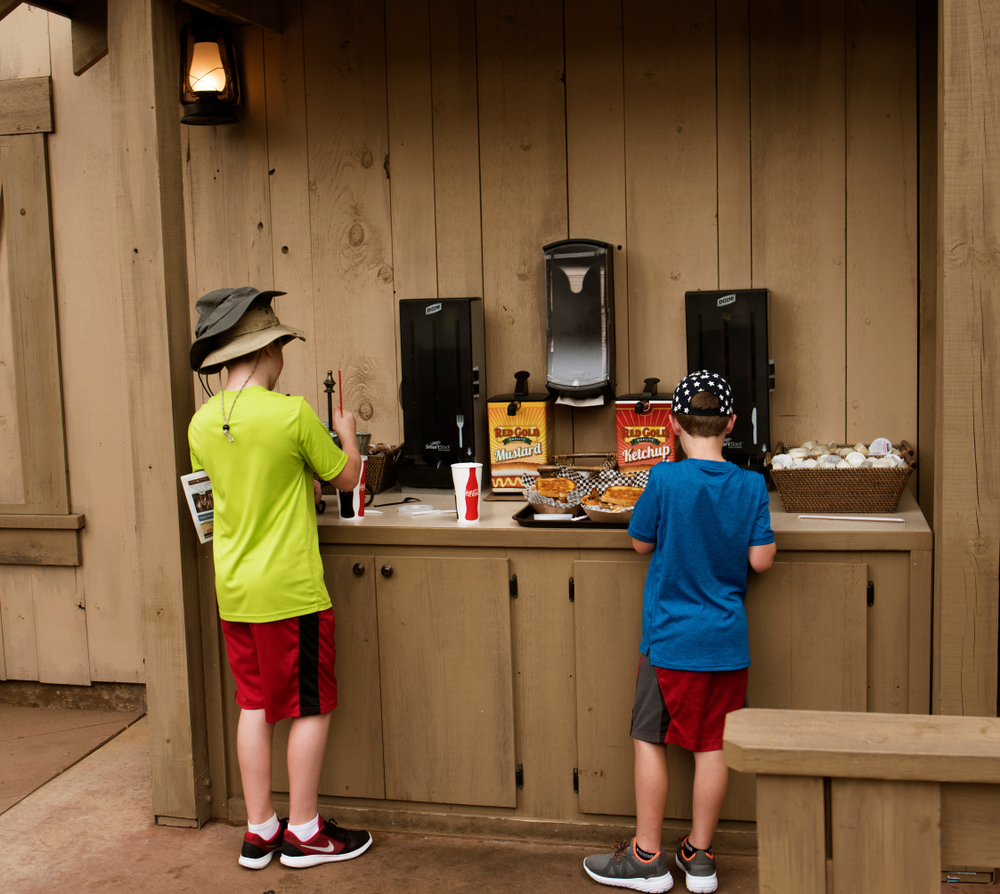 Two children at a fast food stand getting condiments for their meal at Silver Doller City one of the amusements parks in the Midwest