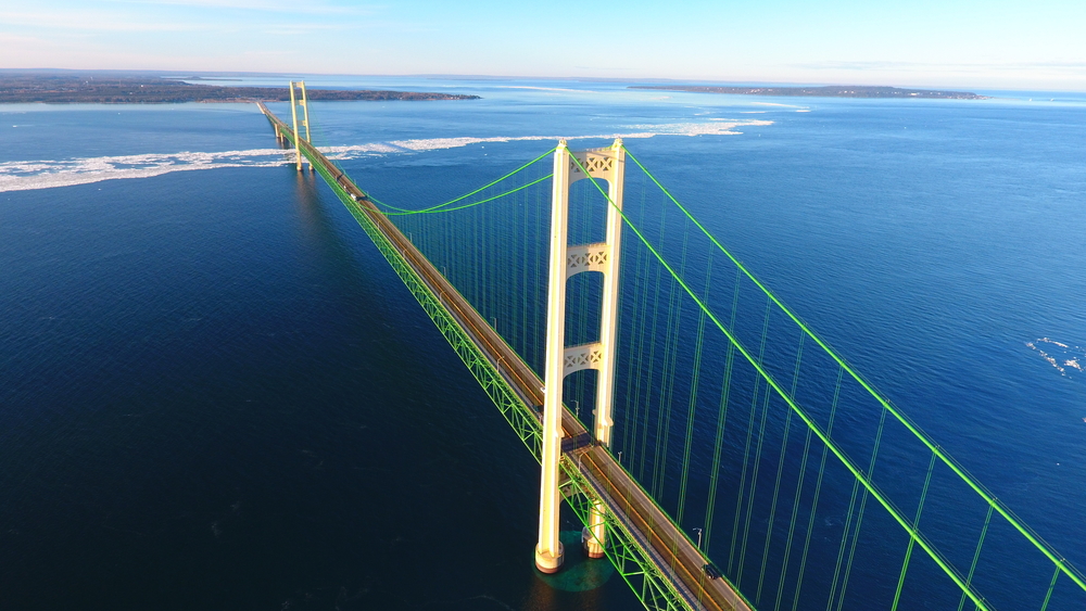 An aerial view of the Mackinaw Bridge over deep blue waters of Lake Michigan
