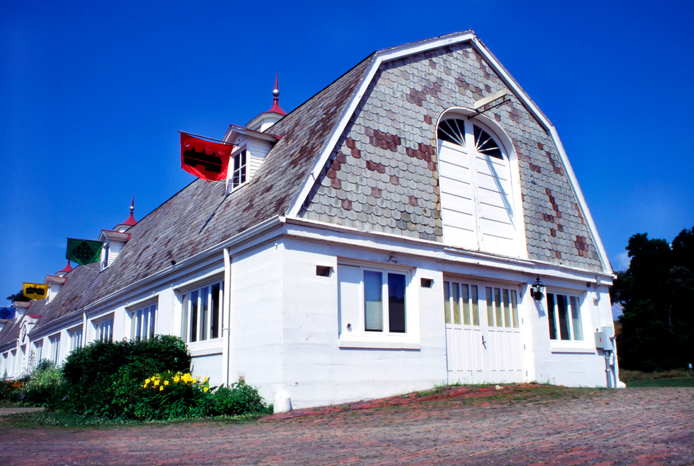 white barn with gray roof with red flags. attraction in Athens Ohio.