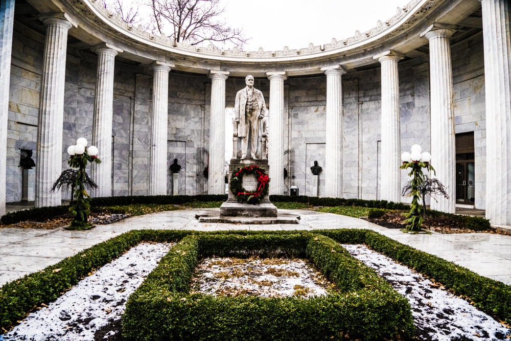 White marble columns in front of white marble building  with stone statue of McKinley in center. 