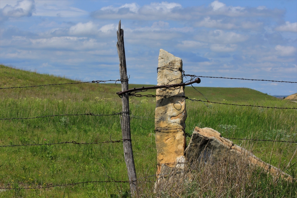 A limestone rock being used as a makeshift fence post on the Post Rock Scenic Byway one of the best Midwest Road Trips