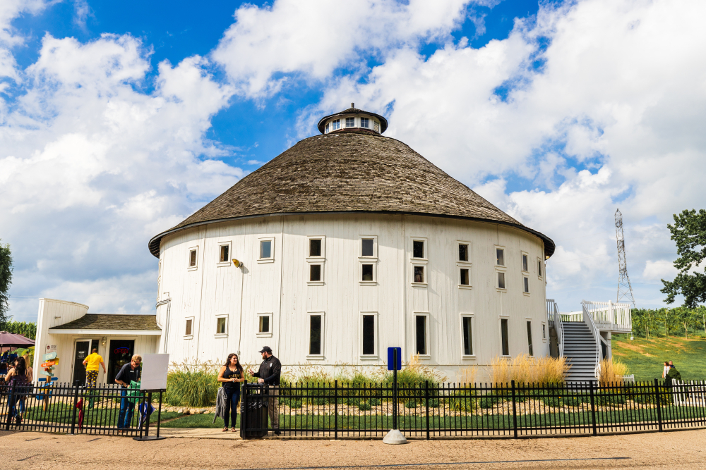 The Round Barn Winery, Distillery, and Brewery on a sunny day with tourists walking around.