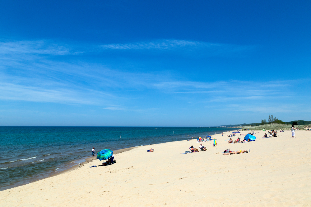 A beautiful white sandy beach on a bright sunny day with clear blue skies in Saugatuck Michigan