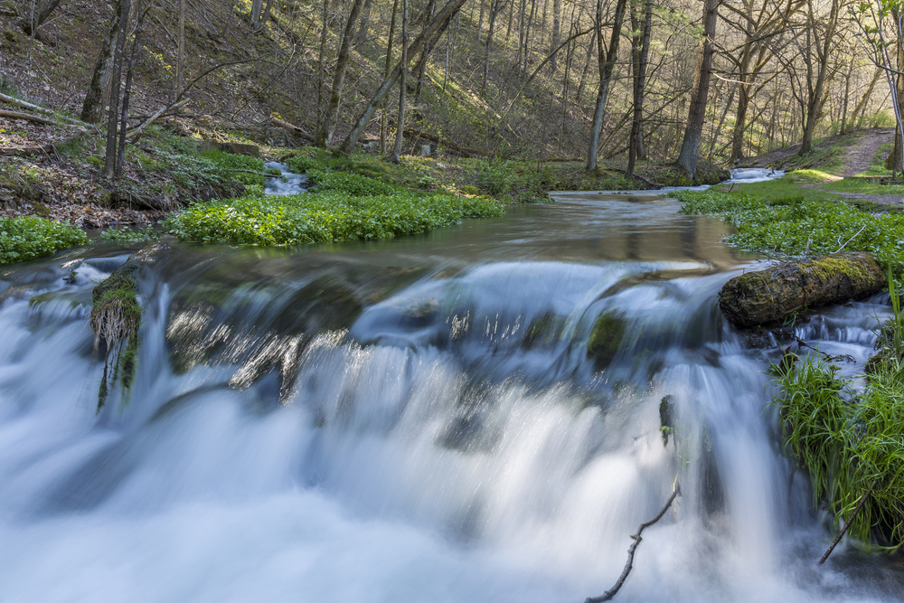 Waterfall in Iowa cascading over rocks into froth of water below.