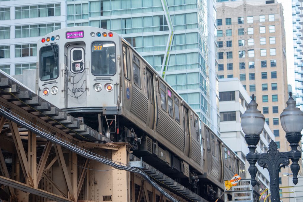 Silver train on elevated track with city skyscrapers in background. 2 days in Chicago.