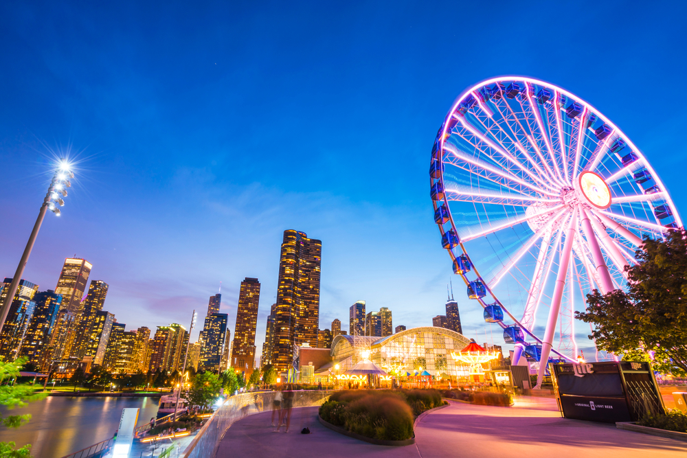 Gleaming Ferris Wheel and city skyscrapers with lights turned on at sunset. 2 days in Chicago itinerary destination.