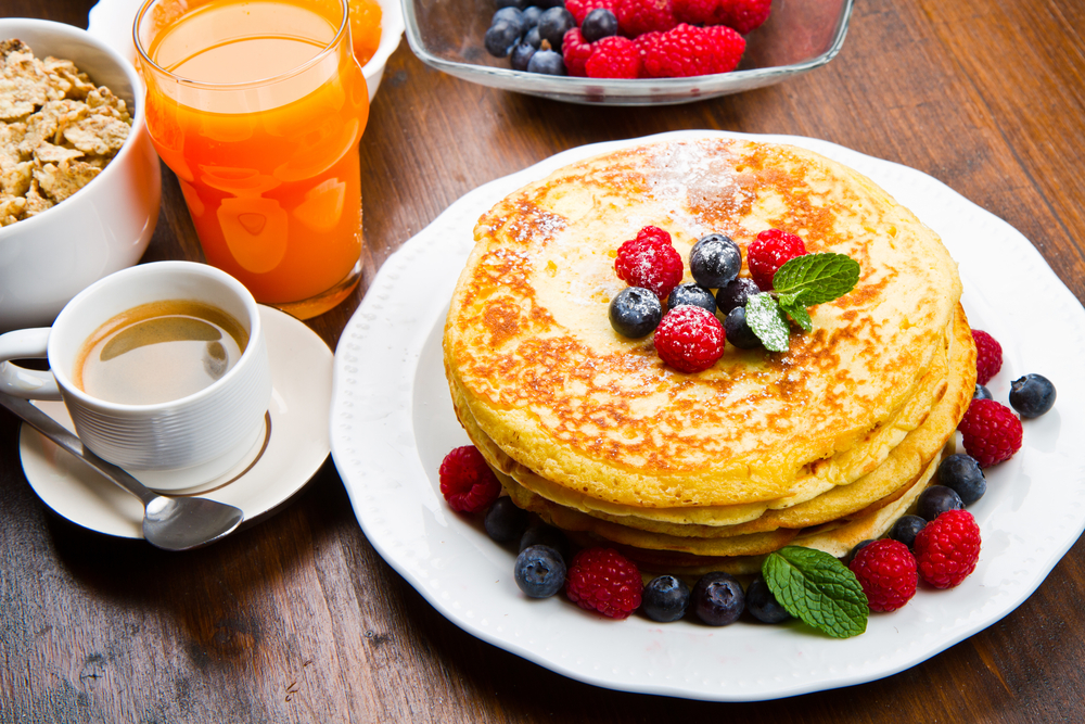 Pancakes and berries alongside a cup of coffee in an article about breakfast in Chicago