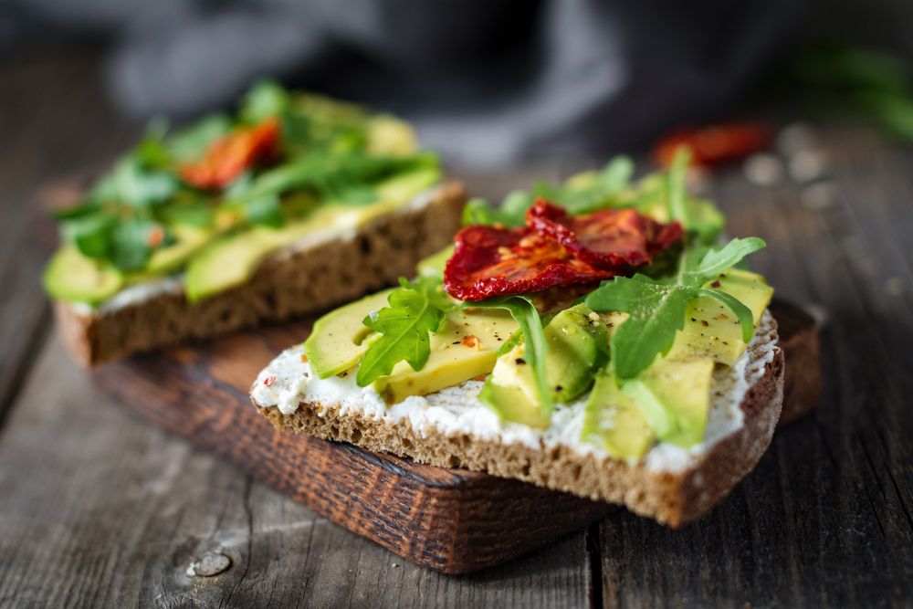 Two pieces of toast with avocado and tomato on in an article about breakfast in Chicago