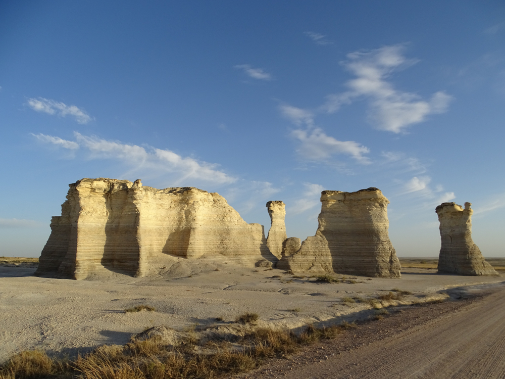 Large chalk rocks standing in a desolate landscape Monument Rocks is one of the things to do in Kansas