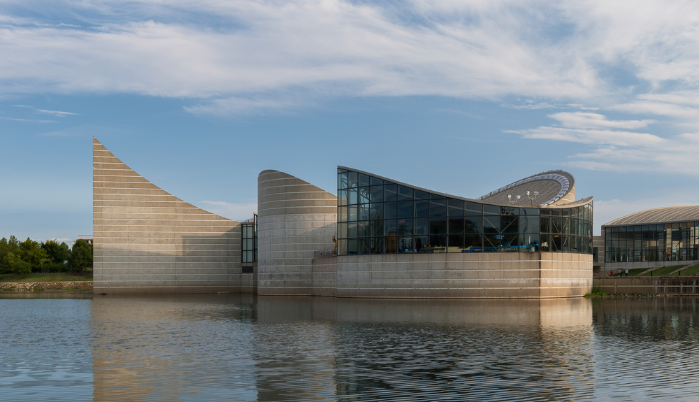 A concrete and glass building surrounded by water