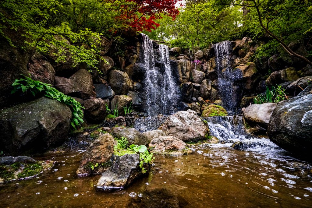 water pouring over the rocks in a Japanese garden