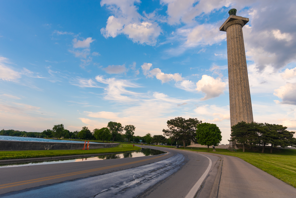 In this Ohio state park, Perry's Peace Memorial is pictured along a winding road against a blue, cloudy sky.