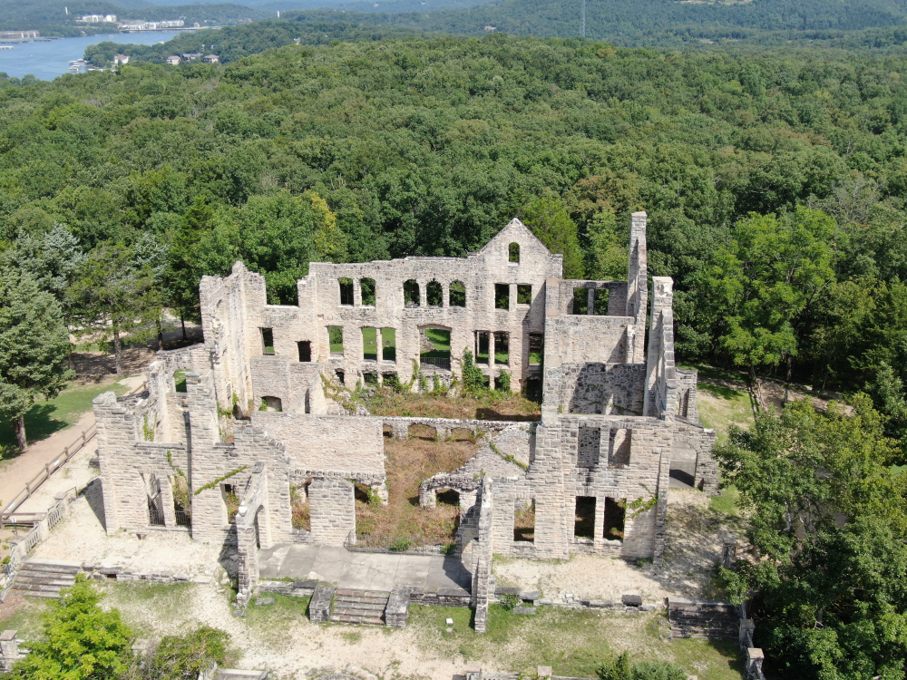 Ruins of white-brick castle surrounded by green trees. things to do in Missouri.