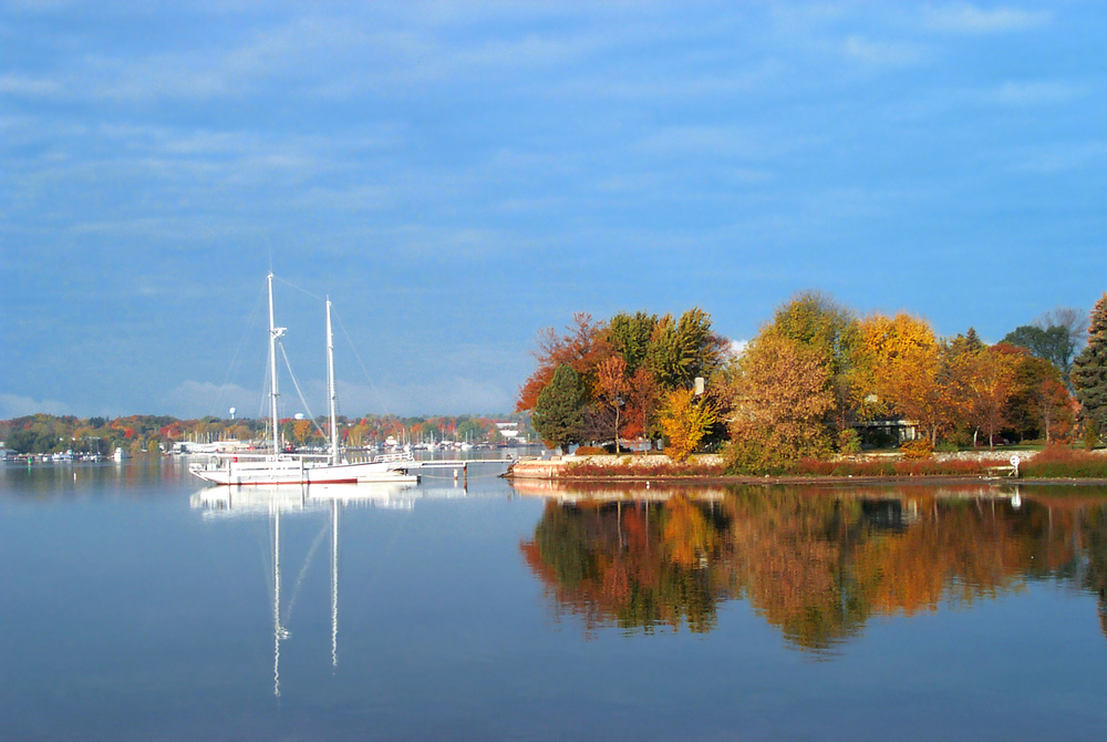 Sturgeon Bay with a boat on and fall colors on the island