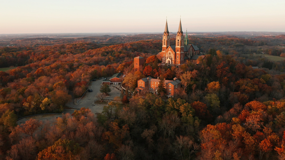 A church on a hill surrounded by beautiful fall colors in an article about Fall in Wisconsin