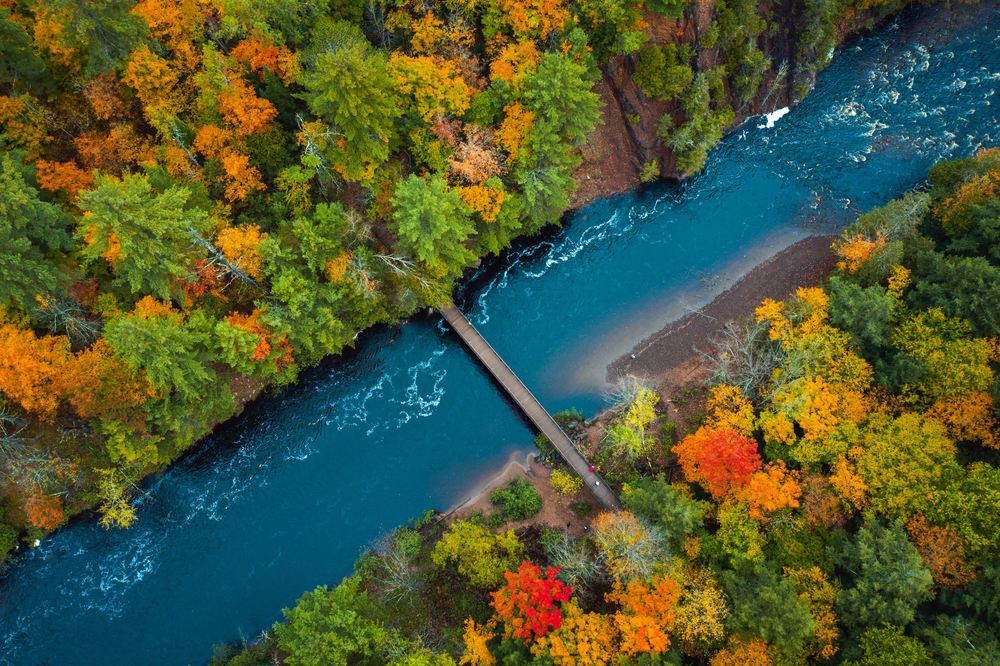 An aerial view of a river and fall trees in an article about fall in Wisconsin