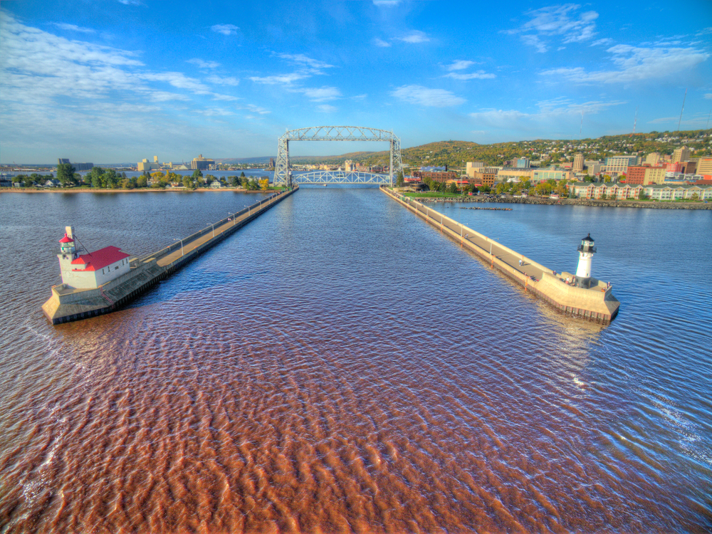 Two lighthouses with the aerial bridge in the background. The lift tower is one of the things to do in Duluth