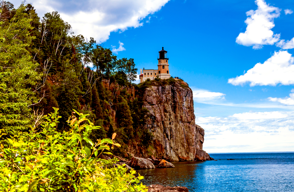 A lighthouse on the top of a cliff overlooking the lake