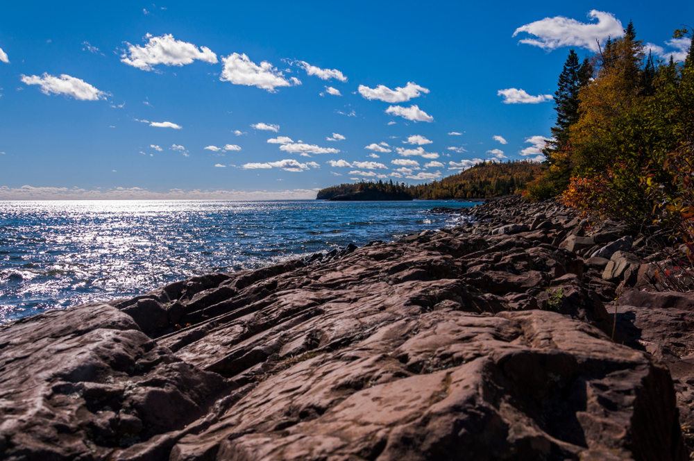 A lighthouse on the top of a cliff overlooking the lake