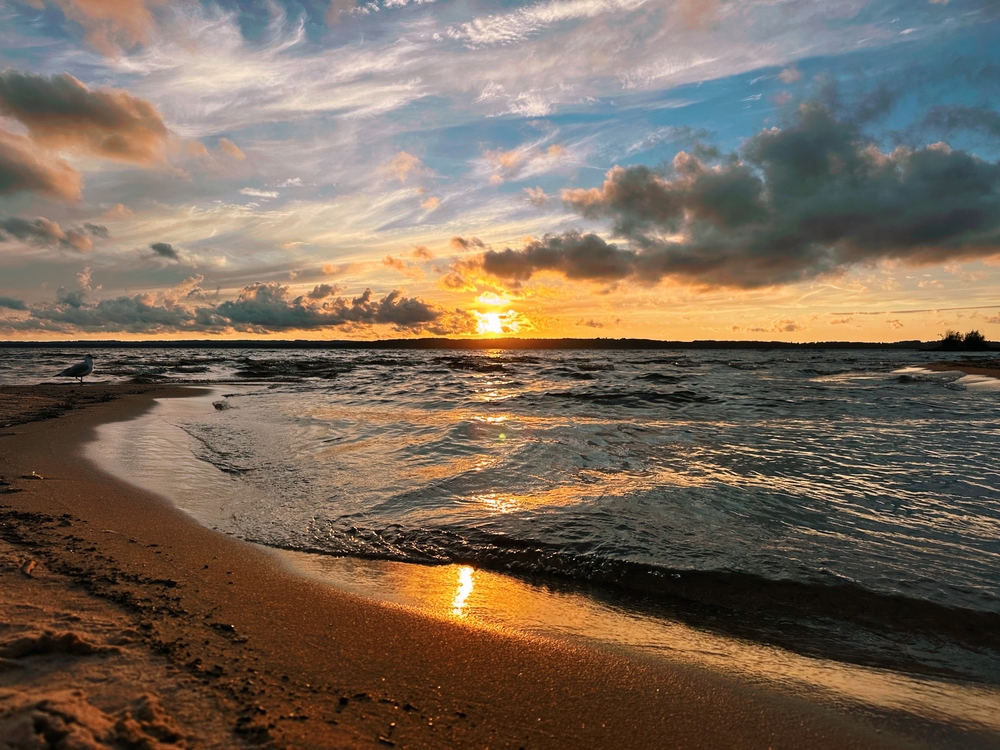 Beautiful Michigan sunset at the beach. the article is about the best beaches in Traverse City 