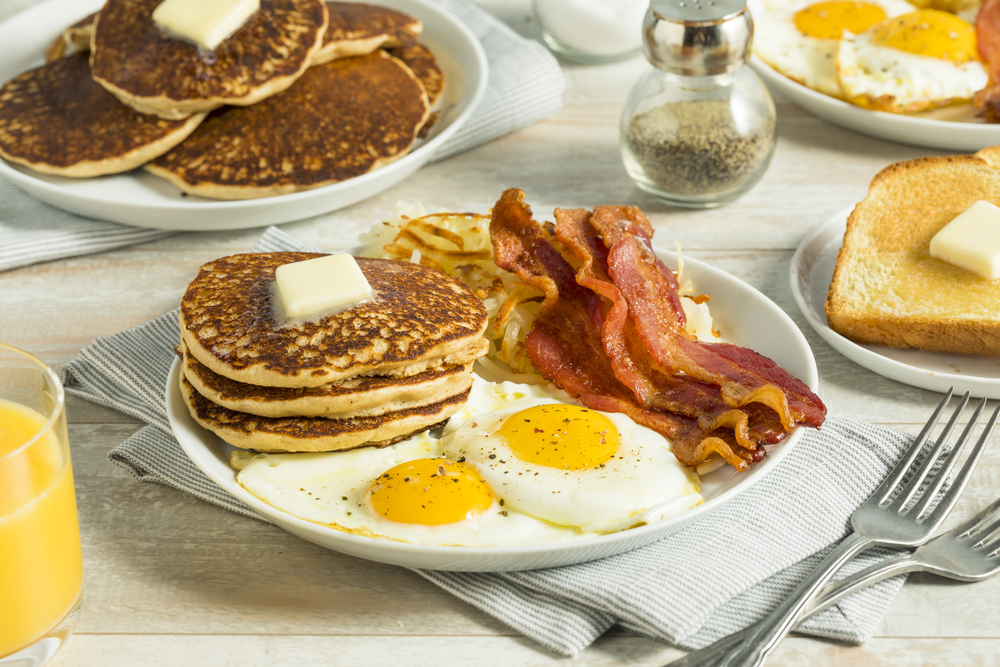 Pancakes, eggs and bacon on a breakfast table