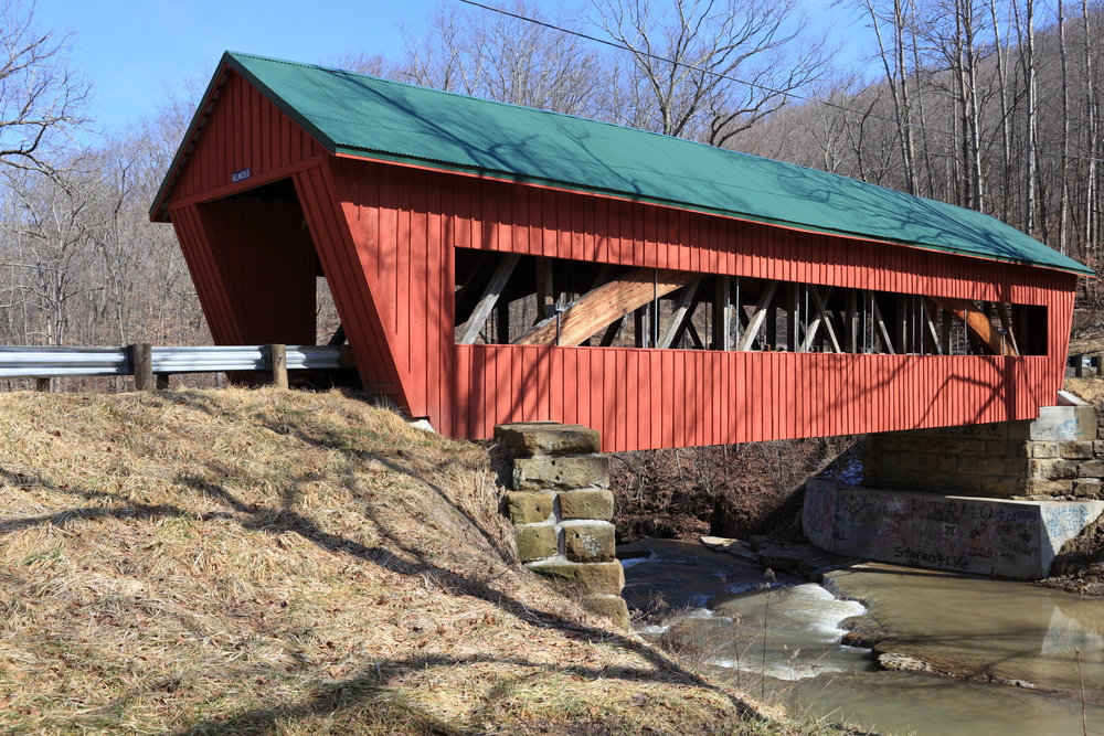 a Red covered bridge with a green roof in Ohio