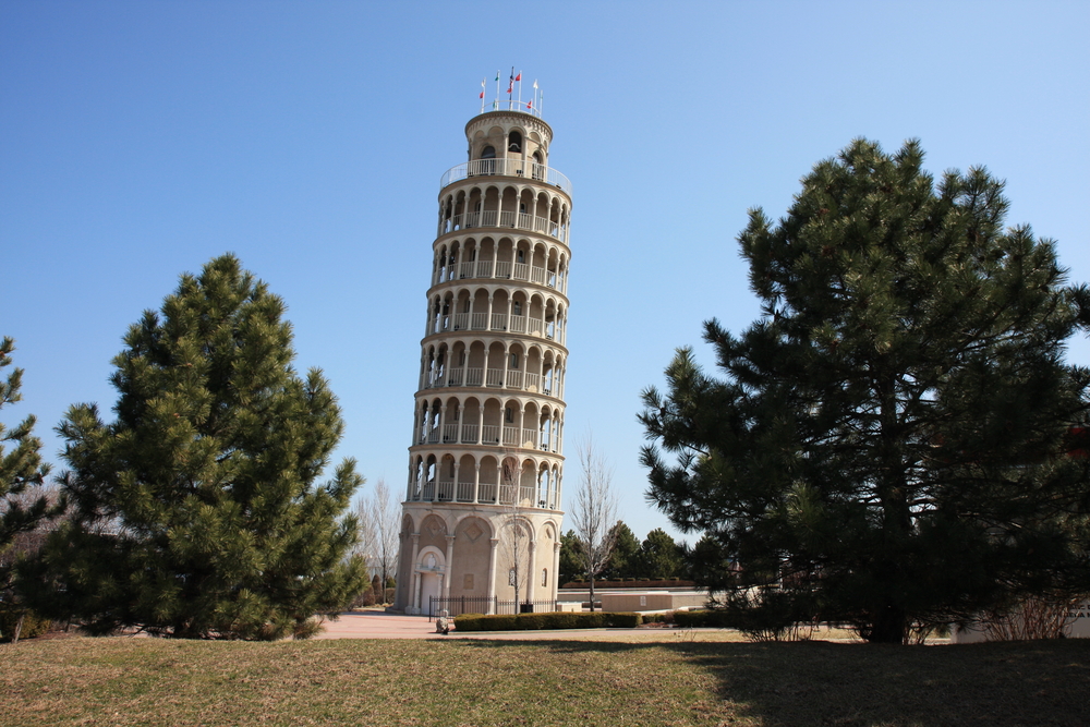 A leaning tower that looks exactly like the Leaning Tower of Pisa in Italy. This one is in a park and there is a courtyard around it. Outside of the courtyard is a grassy area with evergreen trees and near the tower are trees with no leaves. It is one of the best things to do in Illinois. 