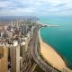 An aerial view of the Oak Street Beach in Chicago. You can see the beach on Lake Michigan and then right behind it is the city skyline of Chicago. The beach and the city extend into the horizon for miles and the water on the lake is very blue. It is one of the best things to do in Illinois