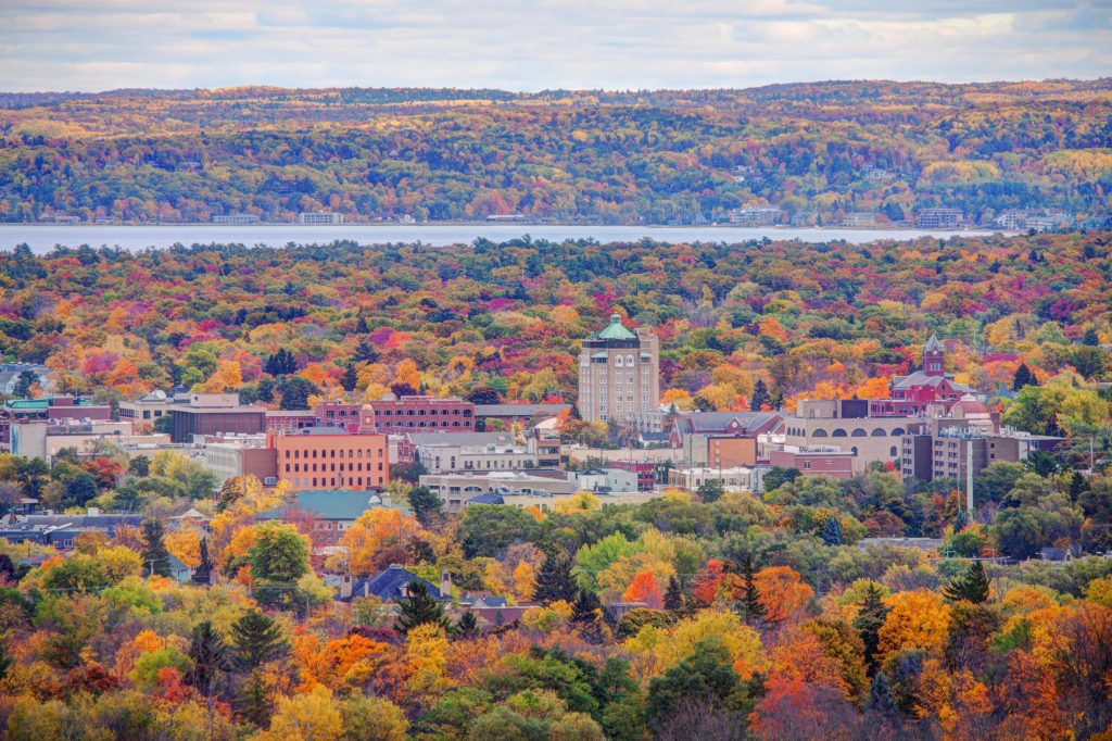 Aerial view of the skyline of Downtown Traverse City surrounded by fall foliage