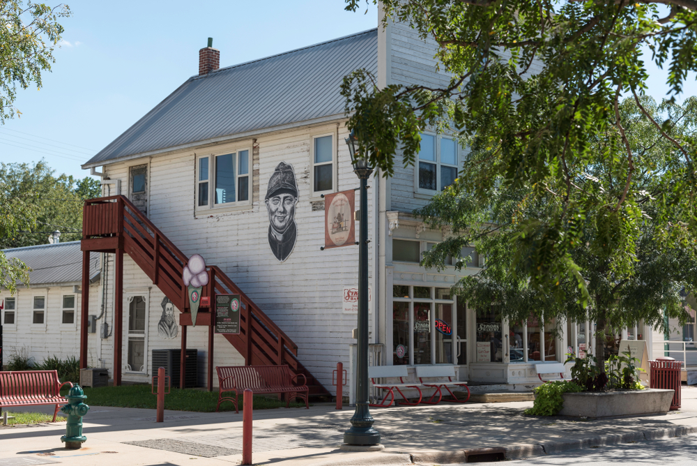 An old, Czech store in downtown Cedar Rapids, one of the best cities to visit in Iowa. The building is white with a mural of a face on the side.