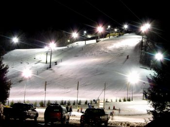 Illuminated Michigan ski resort with bright lights and packed snow