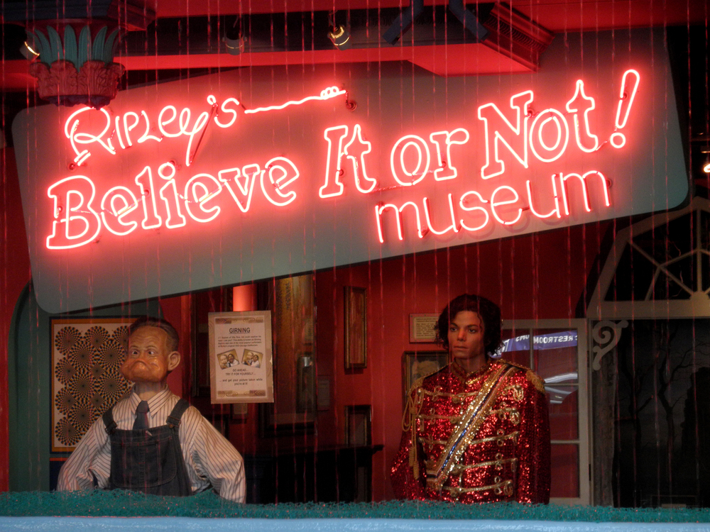 A red neon sign that says 'Ripley's Believe it or not! Museum'. Under it there is an assortment of oddities like a sculpture of a man with an odd face and a wax figure of Michael Jackson wearing a red glittery jacket.
Wisconsin Dells attraction
 