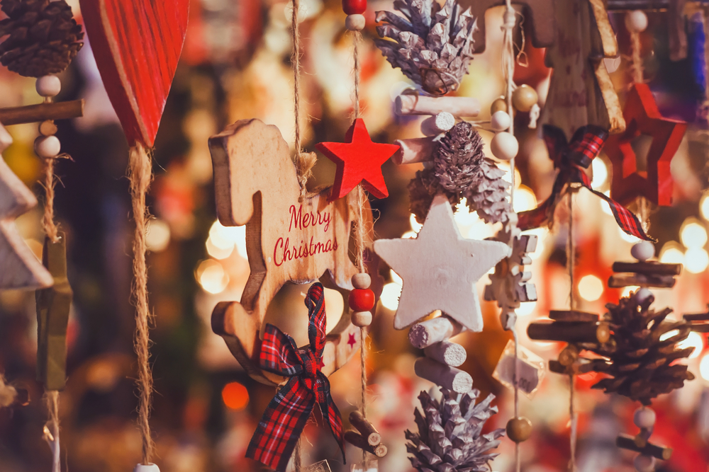 Handmade Christmas decorations made from wooden stars and pine cones at a market.