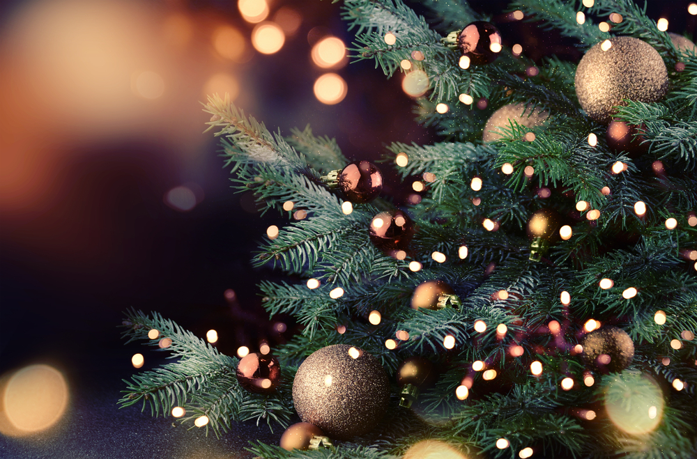 Close-up of lights and gold ornaments on a Christmas tree.