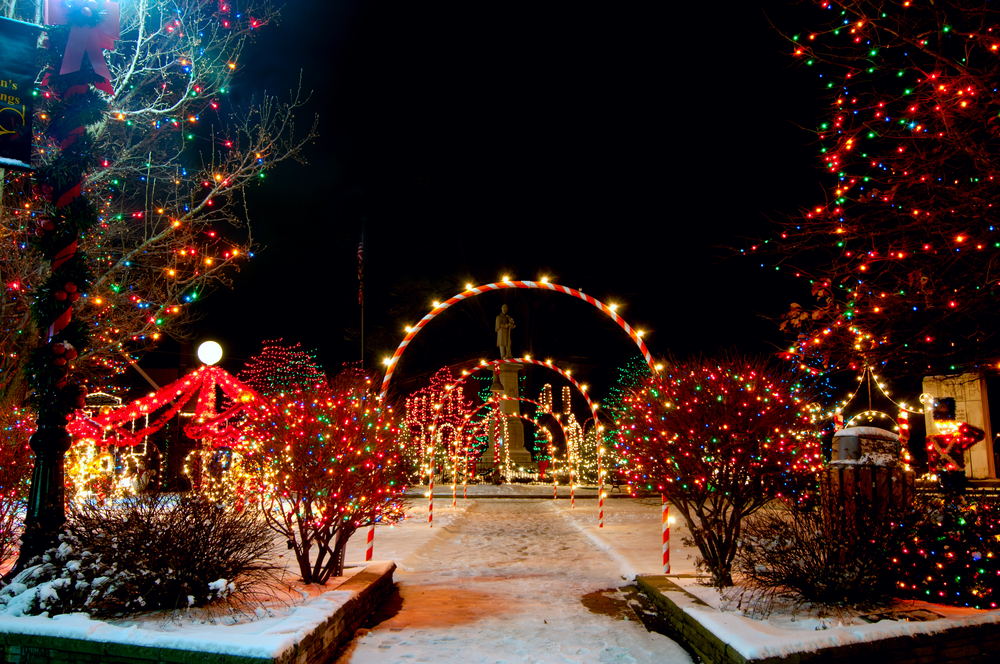 Brilliant Christmas lights in Ohio with illuminated arches, trees, with snow on ground.