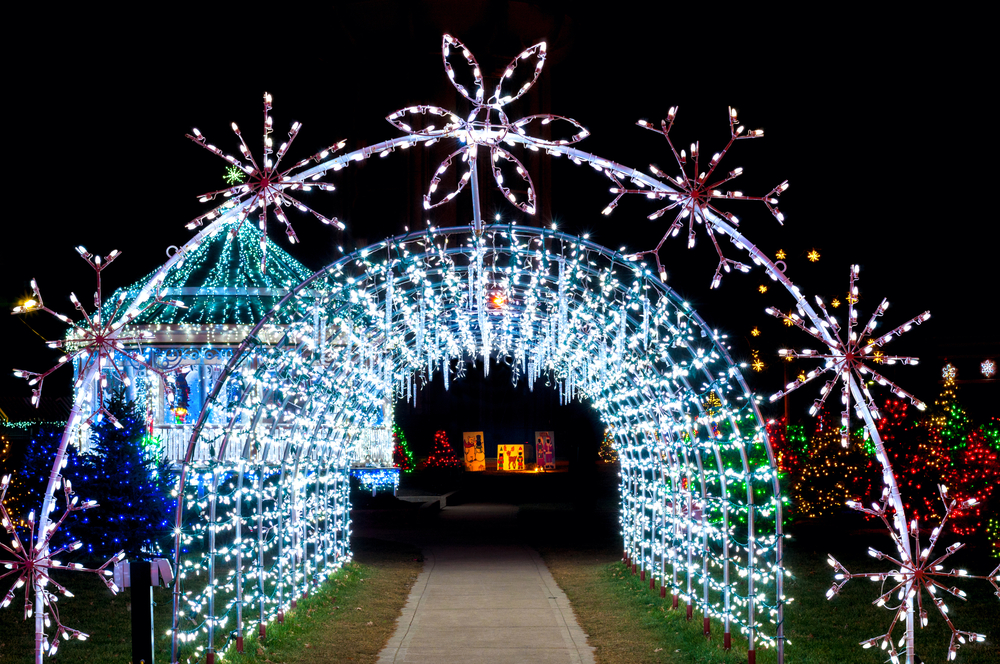 Tunnel of white lights adorned with large snowflake lights.